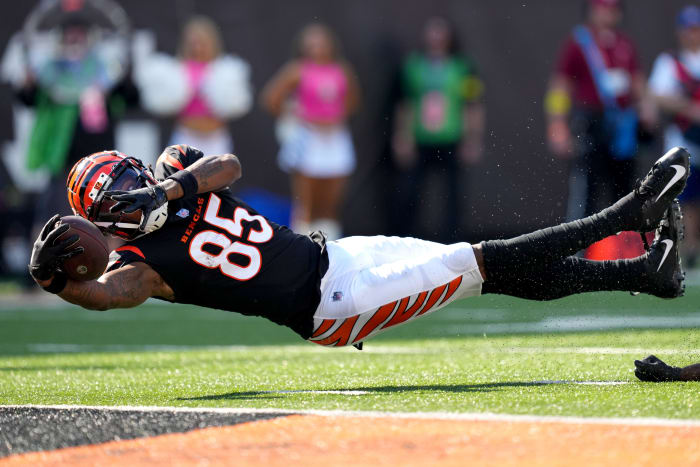 Tee Higgins is horizontal in the air stretching to catch the ball close to the ground